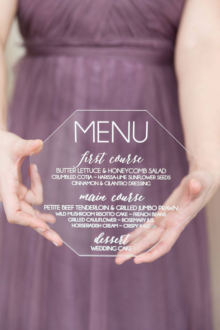 a woman in a purple dress holding up a glass plate with the words menu on it