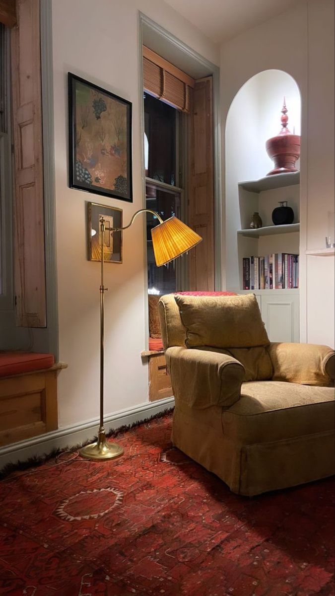 a living room with a chair, lamp and bookshelf