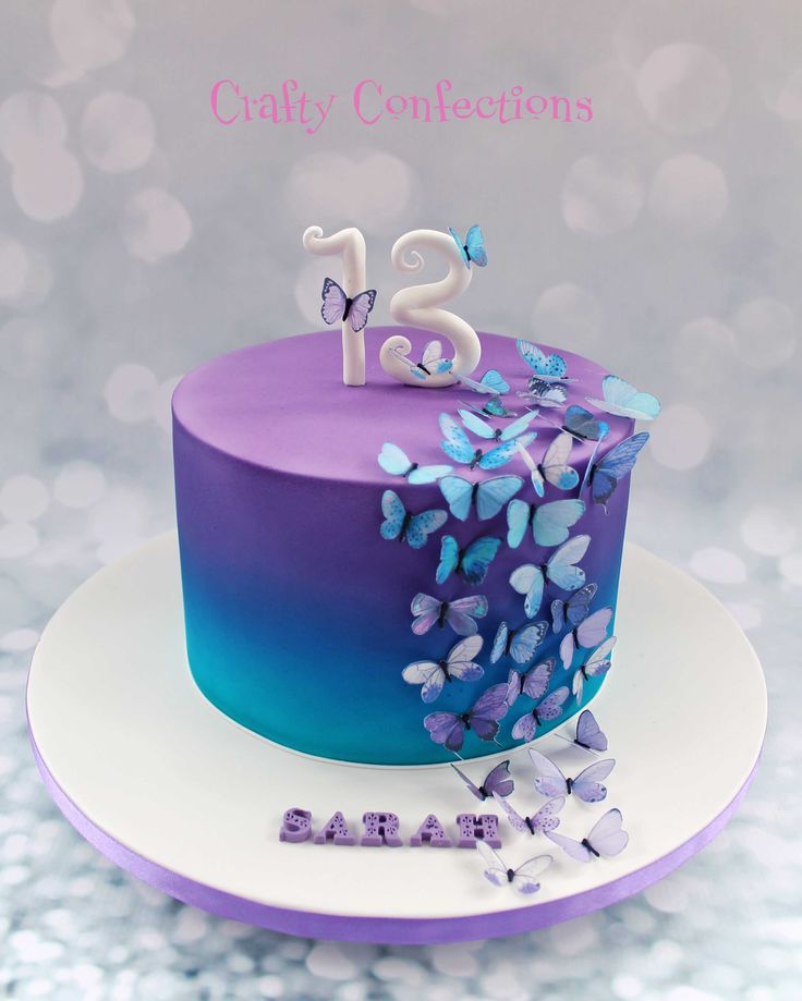 a purple and blue birthday cake with butterflies on the top that says,'28 '