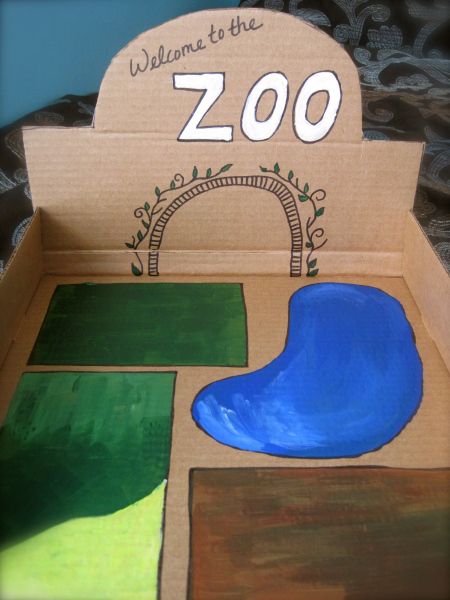 a cardboard box that has some paintings on it with the words welcome to the zoo