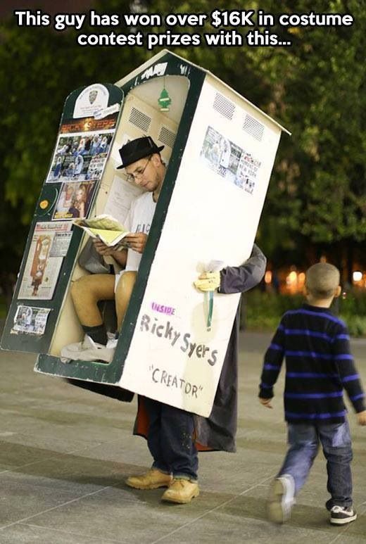 a man in a costume is walking next to a little boy with a sign on his head