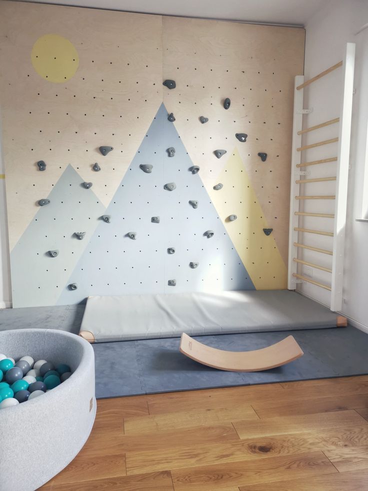 a child's playroom with climbing walls and balls on the floor in front of it