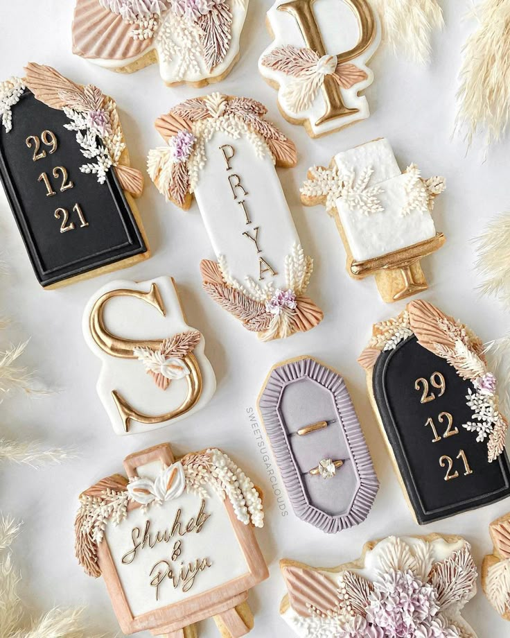 decorated cookies with names and date displayed on white tablecloth for wedding or special occasion