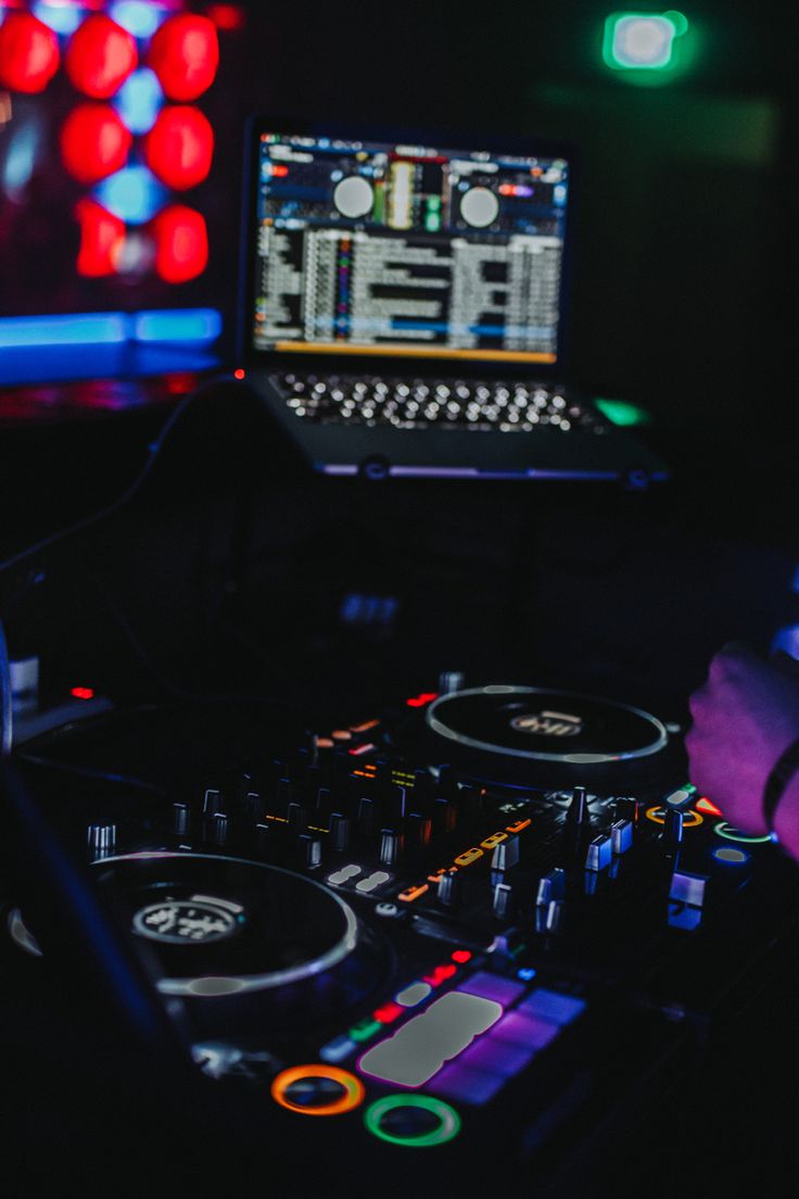 a dj mixing music in front of a laptop