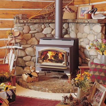 a wood burning stove sitting inside of a living room next to a pile of logs