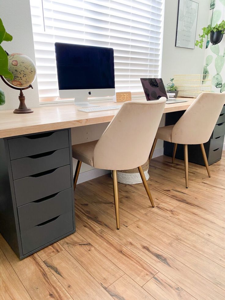 a desk with two chairs and a computer on it