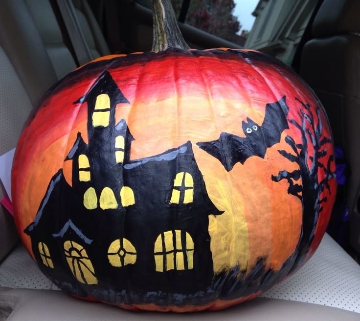 a pumpkin decorated to look like a house with bats on it