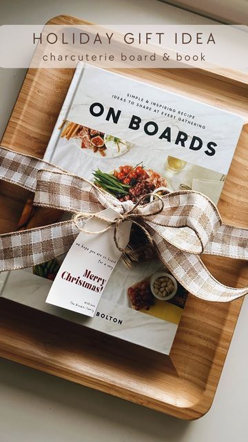 the book on boards is tied with a brown ribbon and sits on a wooden tray