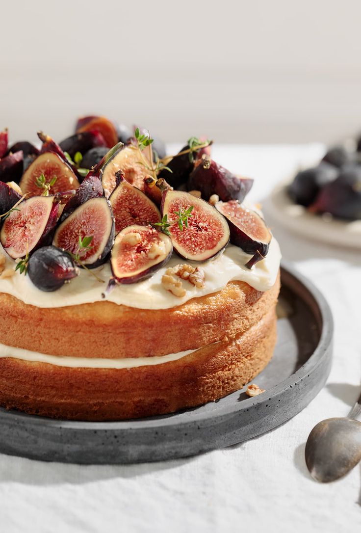 a cake with figs and cream frosting on a plate