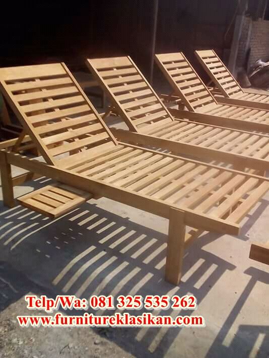 wooden lounge chairs are lined up on the ground