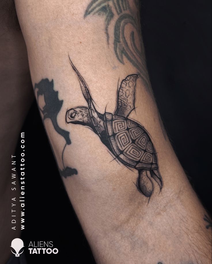 a tattoo on the arm of a man with a turtle