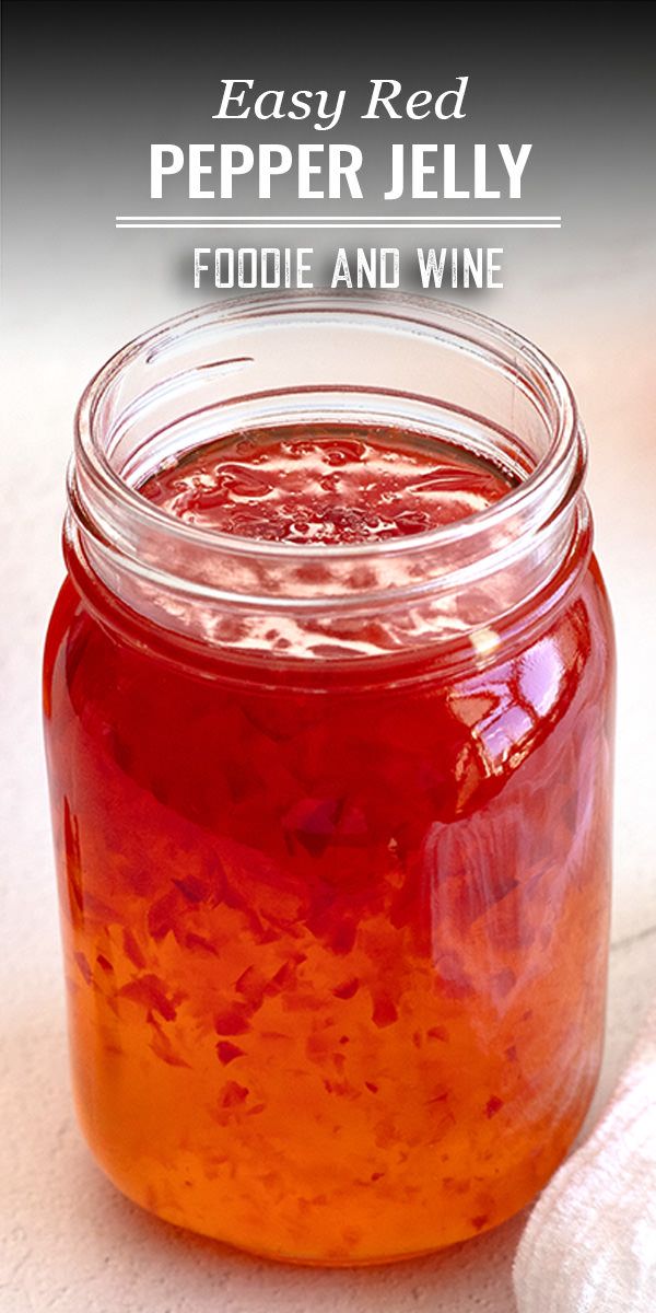 a jar filled with food and wine sitting on top of a table next to a white towel