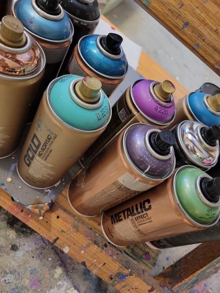 several spray paint cans are stacked on top of each other in the process of being painted