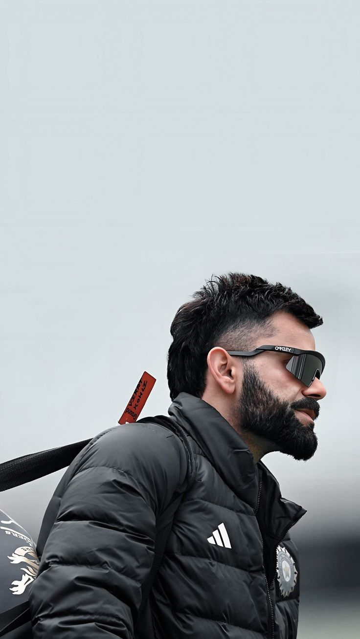 a man with a beard wearing sunglasses and holding a baseball bat