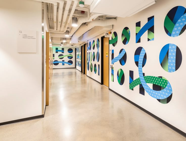 an office hallway with colorful artwork on the wall