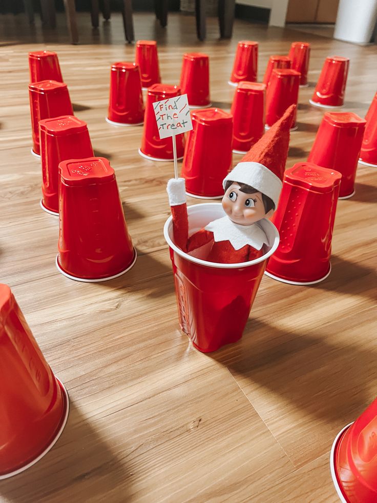 an elf in a bucket surrounded by red cups