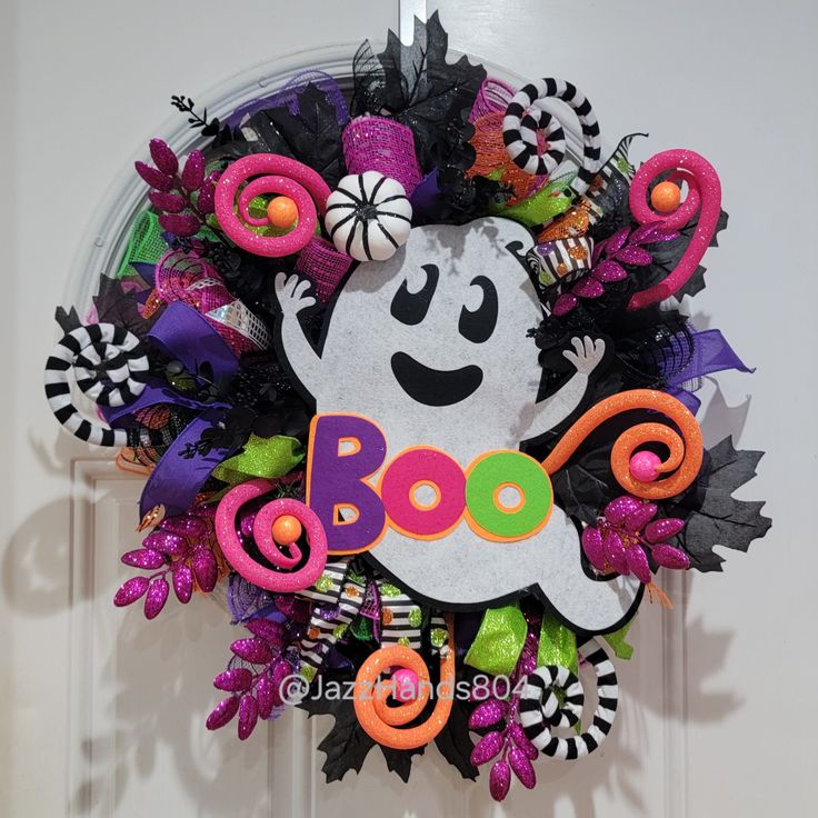 a wreath decorated with halloween decorations and the word boo on it