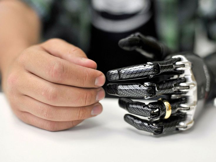 a person holding a robotic hand on top of a table