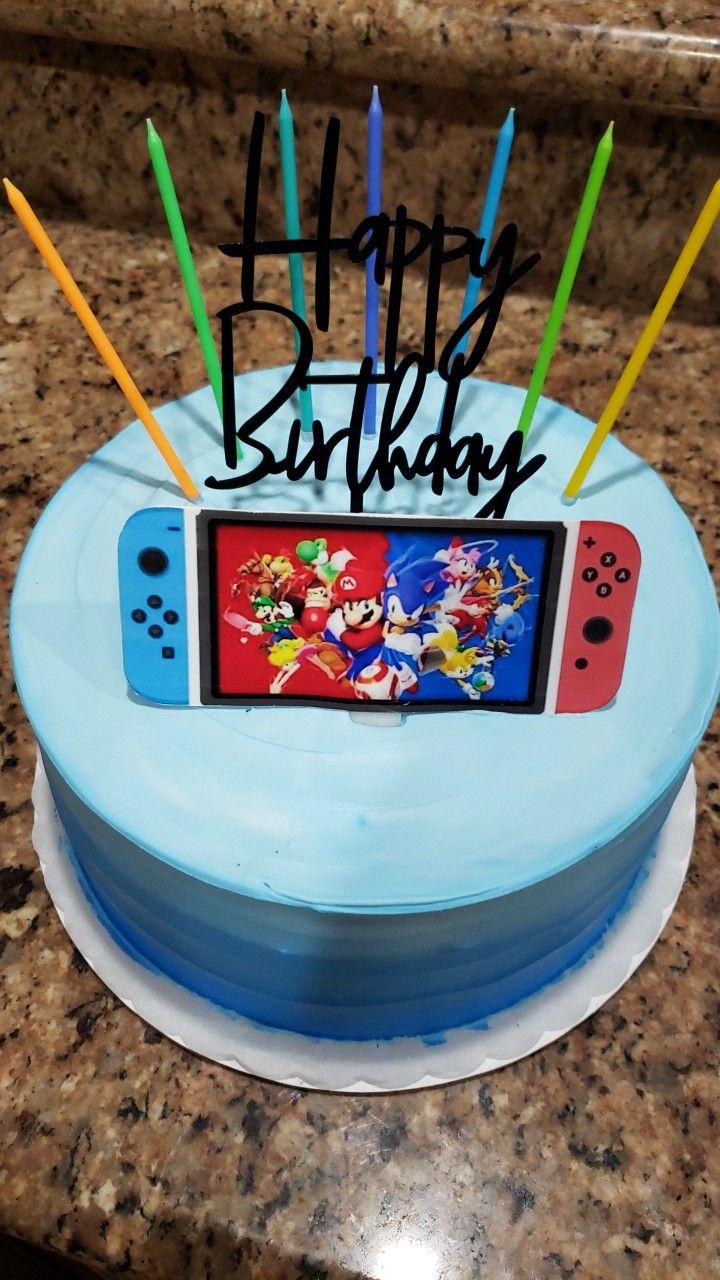 a birthday cake with an image of nintendo wii game console on it and candles sticking out of the top