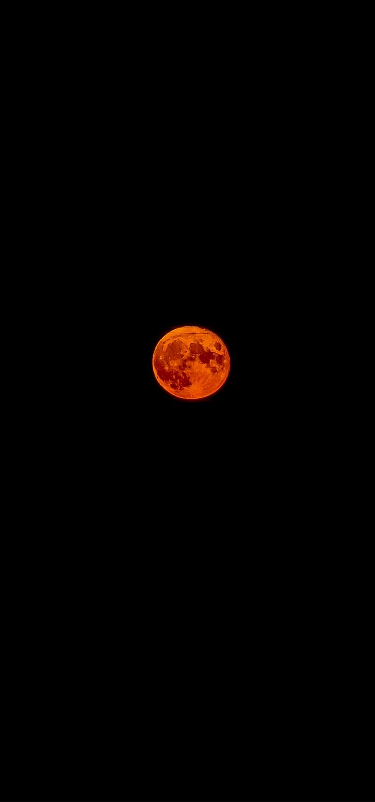 an orange frisbee in the dark sky with no one on it's side