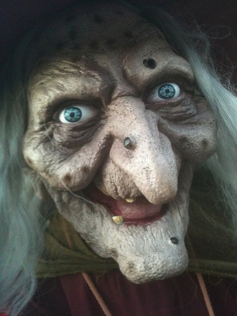 an old woman with white hair and blue eyes is dressed in a creepy costume for halloween