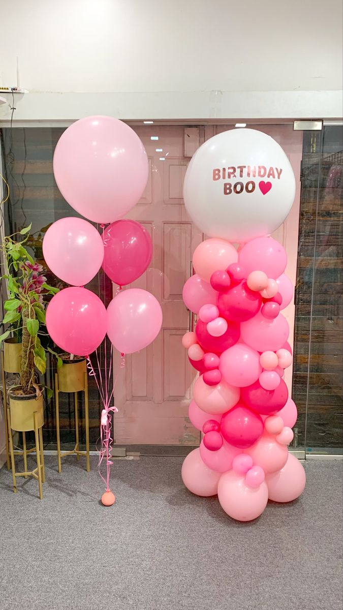 pink balloons are in front of a birthday balloon display