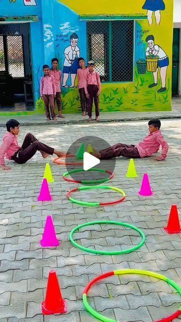 two young boys playing with colorful plastic rings on the ground in front of a building