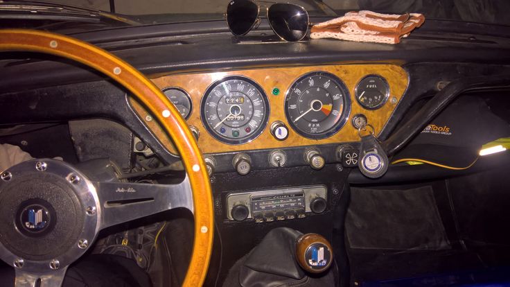 the interior of an old car with wood trim and gauges