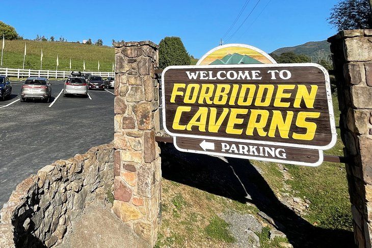 a welcome sign to the parking lot for forbidden caverns