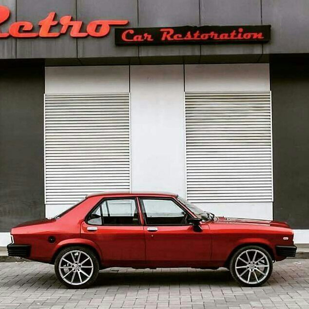 a red car is parked in front of a building with the word retro on it