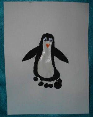 a drawing of a penguin sitting on top of a piece of paper with an orange heart