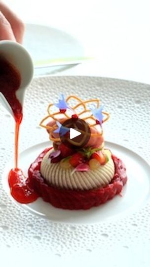 someone is pouring sauce on a small dessert