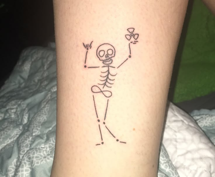 a person with a tattoo on their leg holding a flower in the shape of a skeleton