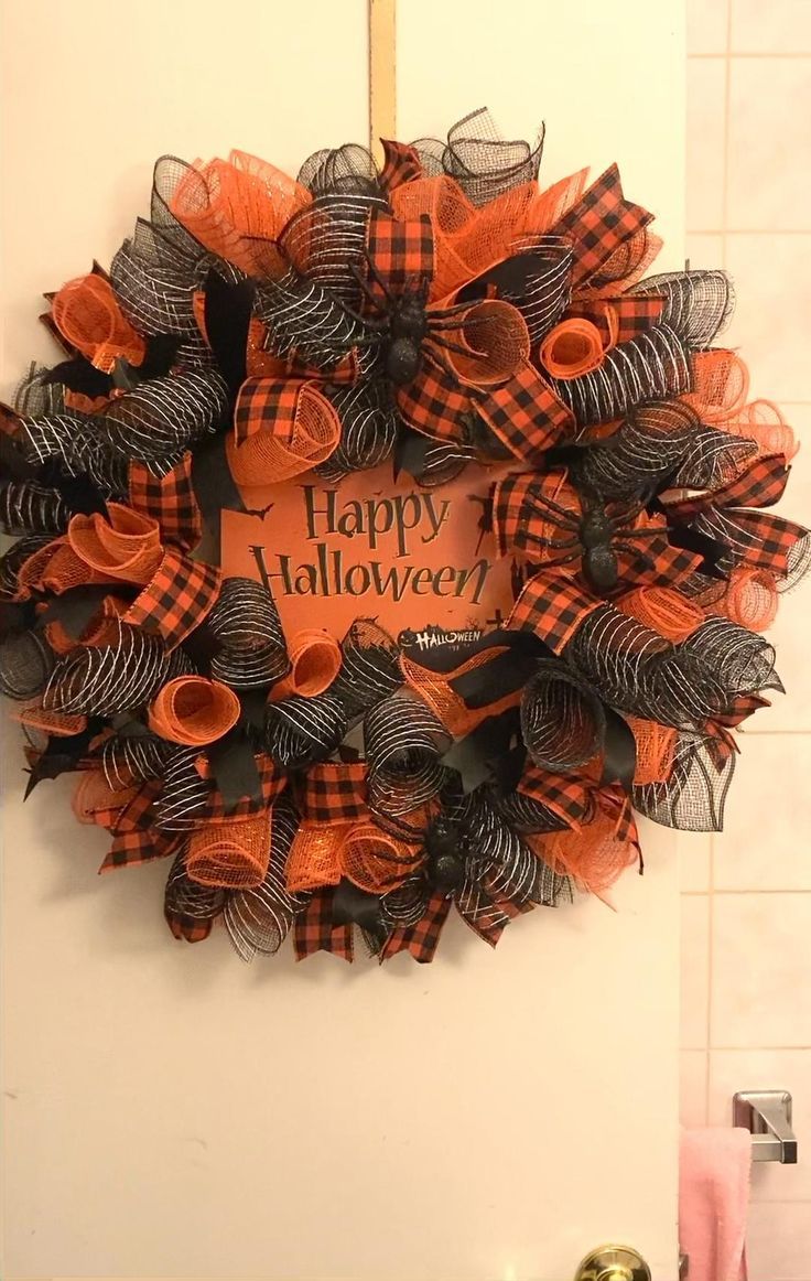 a happy halloween wreath hanging on the front door