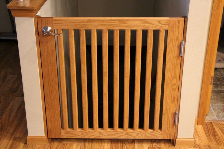 a dog is laying on the floor in front of a wooden door with slats