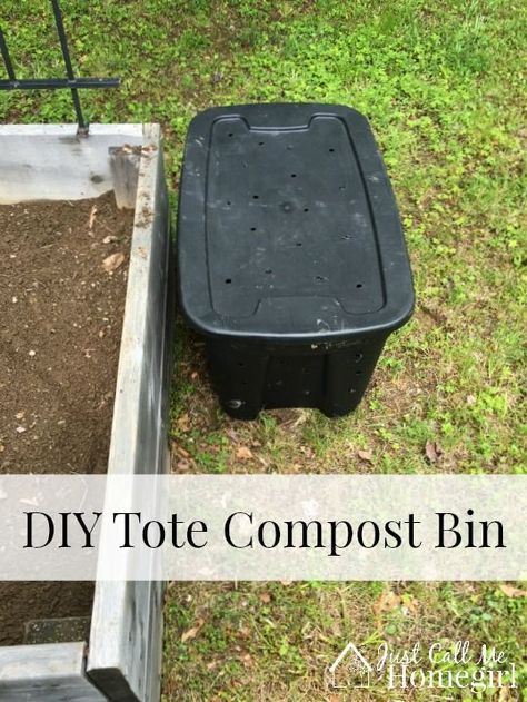 an empty compost bin sitting in the grass next to a wheelbarrow filled with dirt