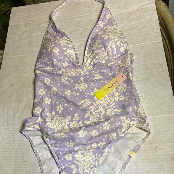 Lavender And White Patterned Swimsuit That Is Padded Lavender Swimwear For Spring Pool Time, Lavender One-piece Swimwear For Summer, Purple One-piece Swimwear For Spring, Purple One-piece Spring Swimwear, Purple Lined Swimwear For Spring, Spring Purple Lined Swimwear, Patterned Swimsuit, Wrap Swimsuit, Swimsuit Pattern