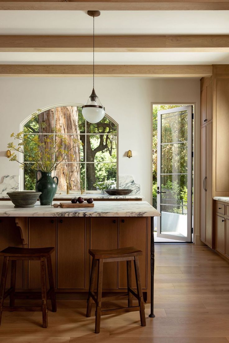 a kitchen with an island and two stools next to the counter top in front of it