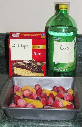 a metal pan filled with raspberries next to a bottle of water