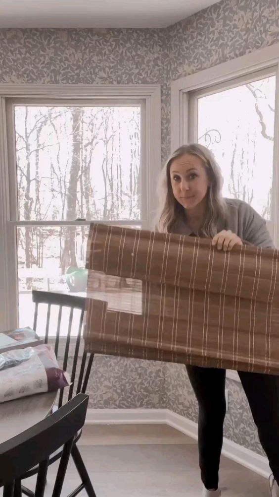 a woman holding up a large piece of furniture