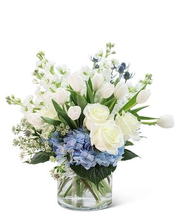 a vase filled with white and blue flowers