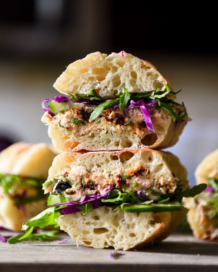 three sandwiches stacked on top of each other with lettuce and meat in the middle