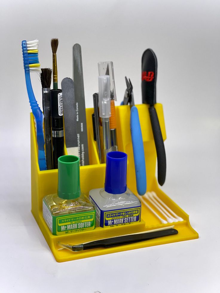 a yellow desk organizer with toothbrushes and other office supplies