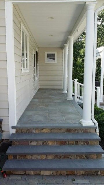 a porch with steps leading up to the front door