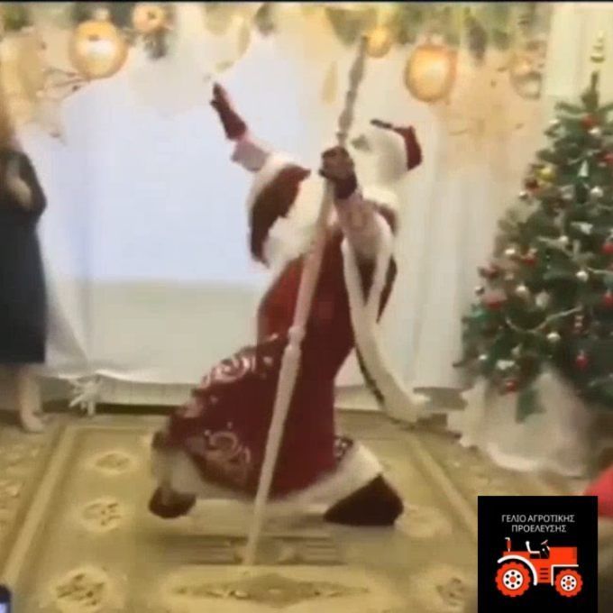 two women dressed as santa clause dancing in front of a christmas tree