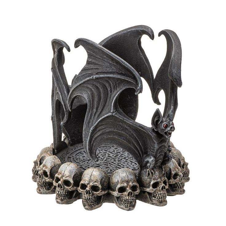 a statue of a bat and skulls on a white background