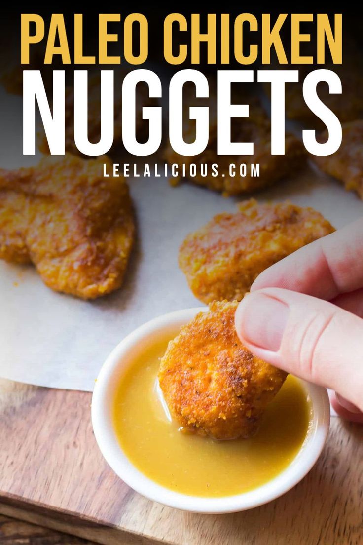 a person dipping sauce on some chicken nuggets in a small white bowl with the words paleo chicken nuggets above it