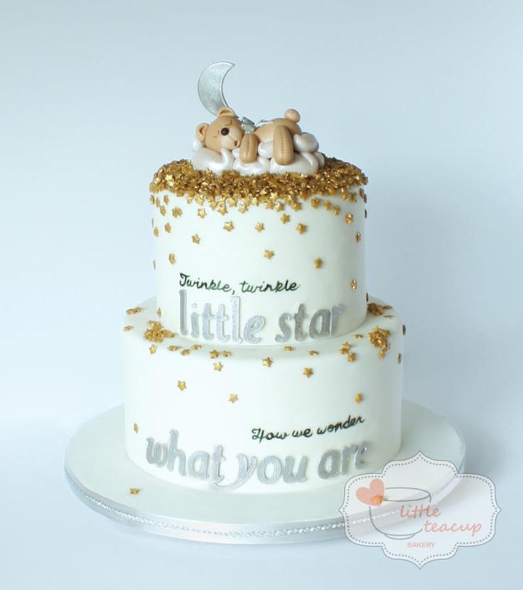 two tiered cake decorated with gold glitters and teddy bears sitting on top of each other