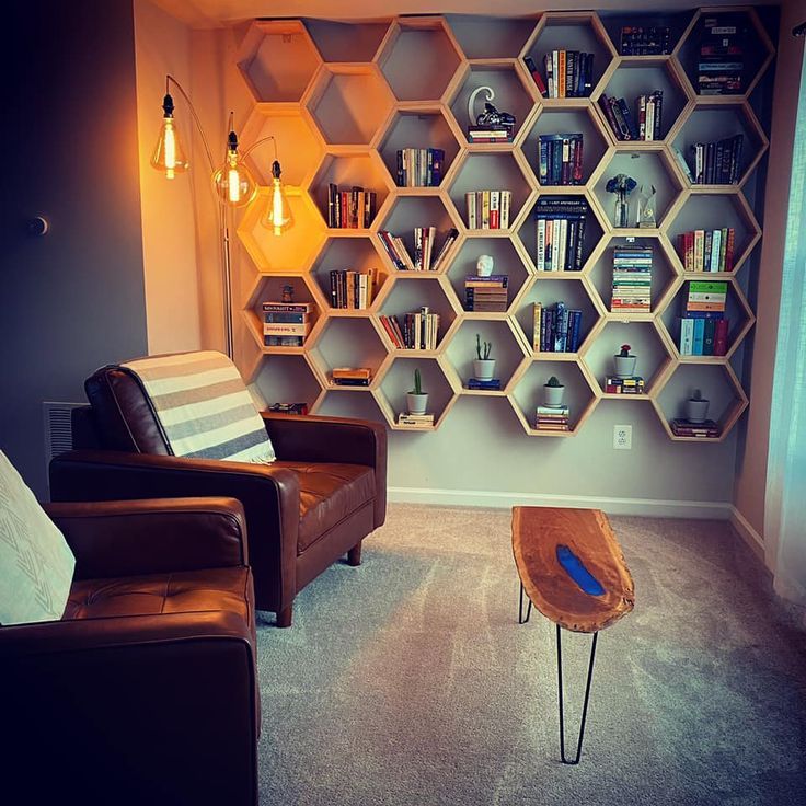 a living room filled with furniture and bookshelves next to a wall mounted book shelf