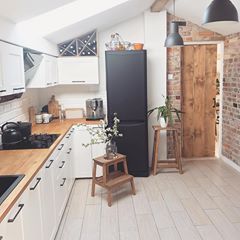 a kitchen with an oven, refrigerator and sink in it's center island next to a brick wall